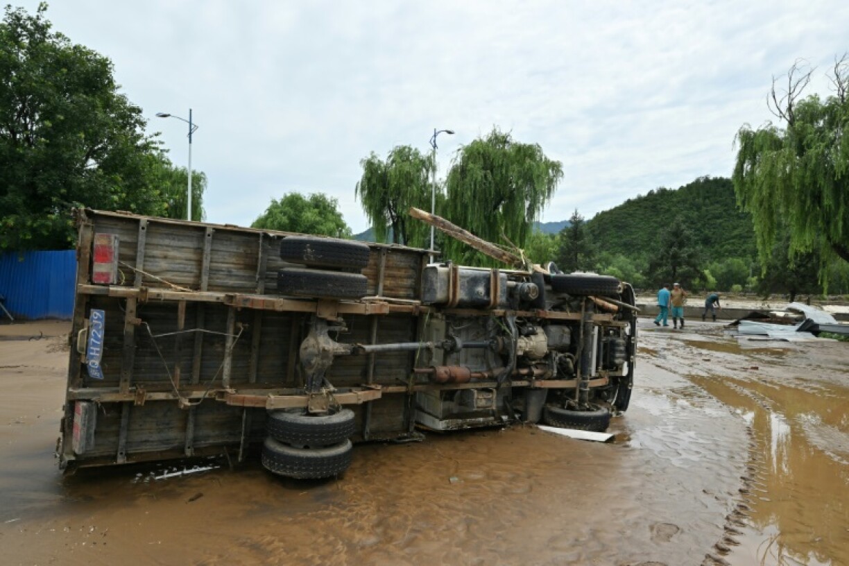 A truck swept away by floodwaters is seen on its side following heavy rain in Miyun district, on the outskirts of Beijing