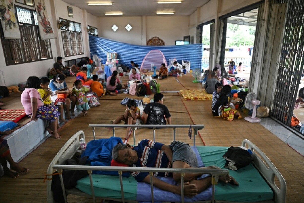 Evacuees displaced by the ongoing conflict between Thailand and Cambodia rest at a makeshift evacuation center inside a Buddhist temple in Thailand's Si Sa Ket province