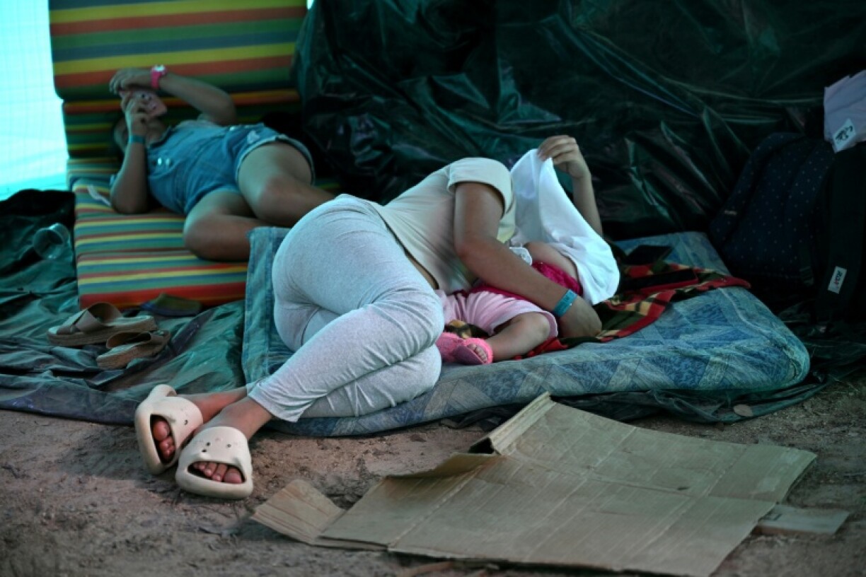 A woman displaced by recent clashes between armed leftist groups hugs a child as she rests outside the Argelino Duran Quintero Coliseum in Ocaña, Colombia