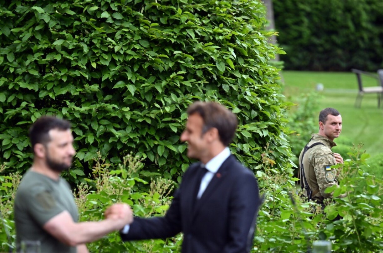 Volodymyr Zelensky se congratulent sous le regard d'un membres des forces ukrainiennes à Kiev, le 16 juin 2022