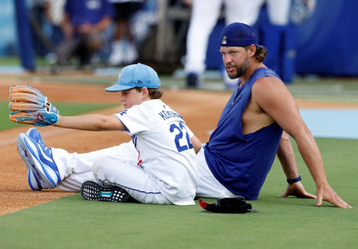 Dodgers pitcher Clayton Kershaw sits with son, Charley, during batting practice before a game at Dodger Stadium, where Kershaw announced he'll retire after the 2025 MLB season