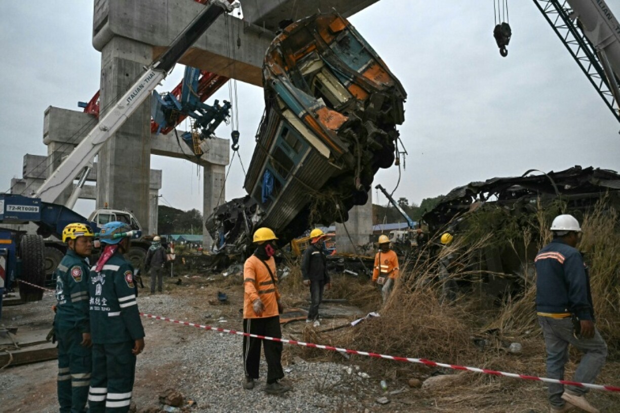 Des secouristes sur le site du déraillement d'un train provoqué par l'effondrement d'une grue de chantier dans la province de Nakhon Ratchasima, en Thaïlande, le 14 janvier 2026
