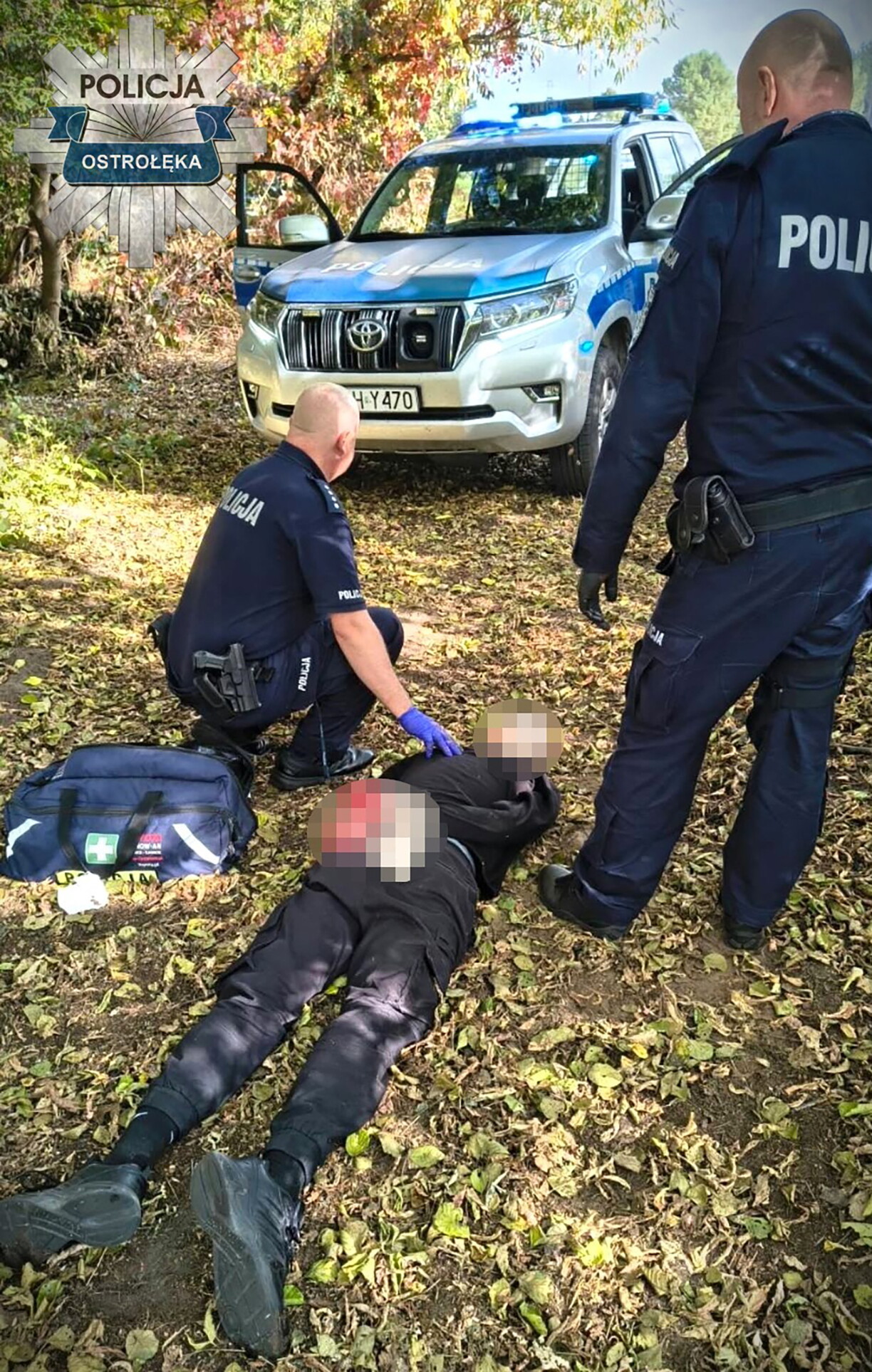 This handout picture taken and released by Policja Mazowsze on October 7, 2026, shows two policemen detaining a suspected high school knife attacker in the town of Ostroleka, some 130 km north of Warsaw.
