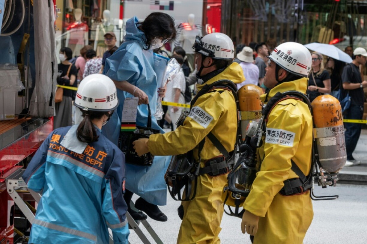 Les secours aident une femme qui était dans un centre commercial quand un homme y a pulvérisé une substance, à Tokyo, le 25 mai 2026