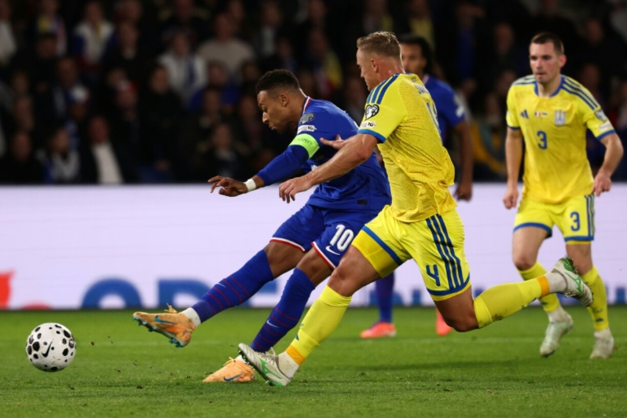Second-half goals by Kylian Mbappe (L) and Michael Olise, as well as a first international strike for Hugo Ekitike, booked France's place at the 2026 World Cup