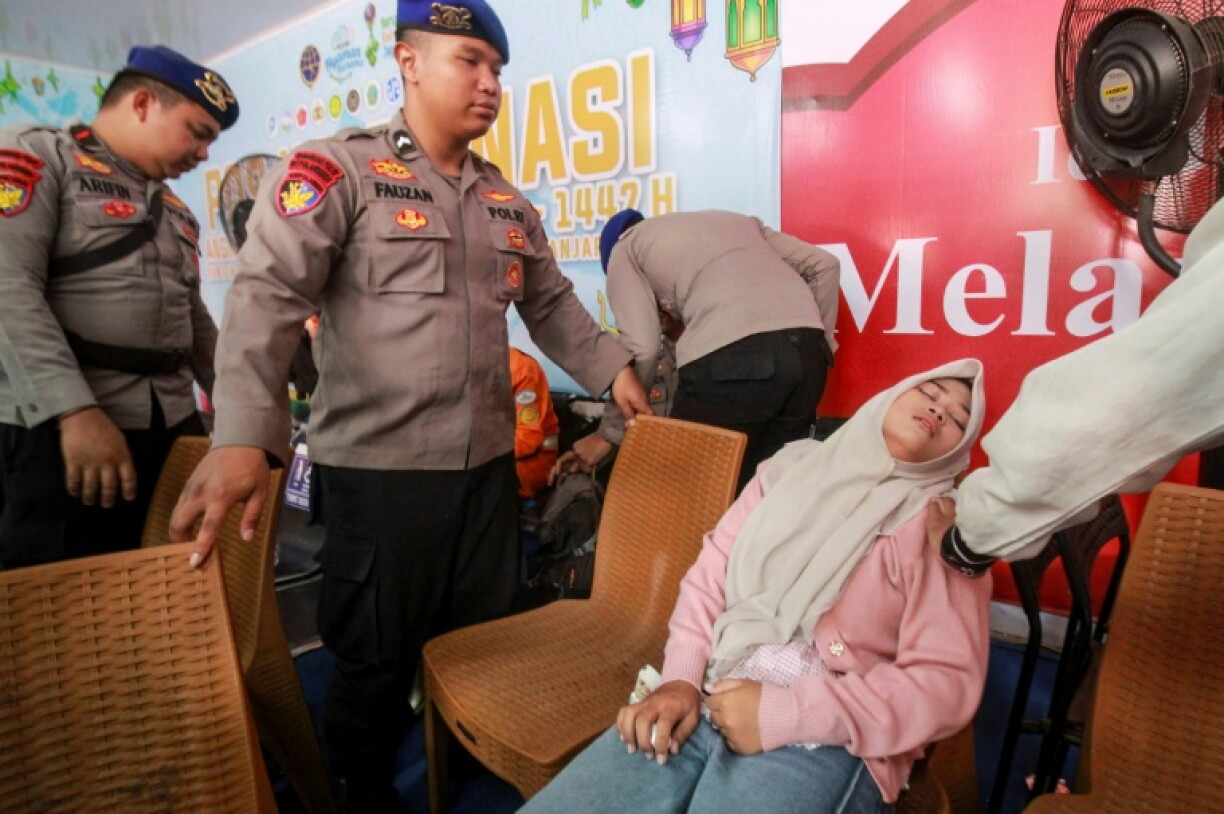 Une femme apprend qu'un proche a survécu au naufrage d'un ferry en mer de Java, le 13 septembre 2026 à Banjarmasin en Indonésie