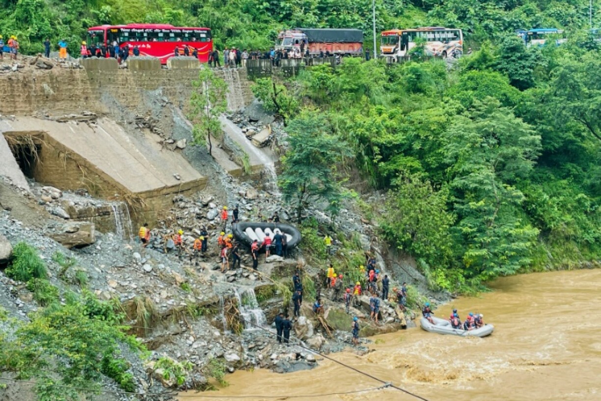 Des équipes de secours recherchent des survivants dans la rivière Trishuli après un glissement de terrain qui a emporté deux bus, le 12 juillet 2024 à Simaltar, au Népal