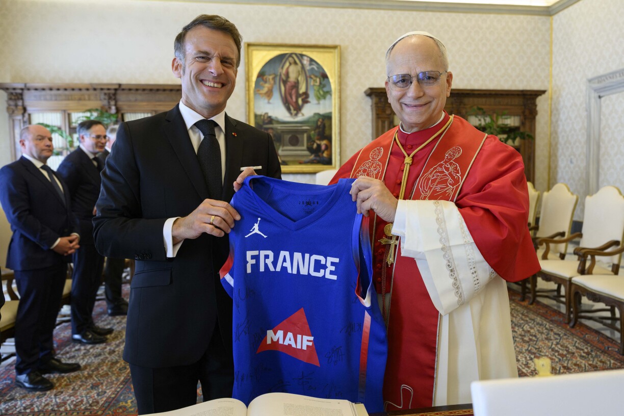 Le pape Léon XIV et Emmanuel Macron, un maillot des Bleus de basket à la main lors de leur rencontre au Vatican.