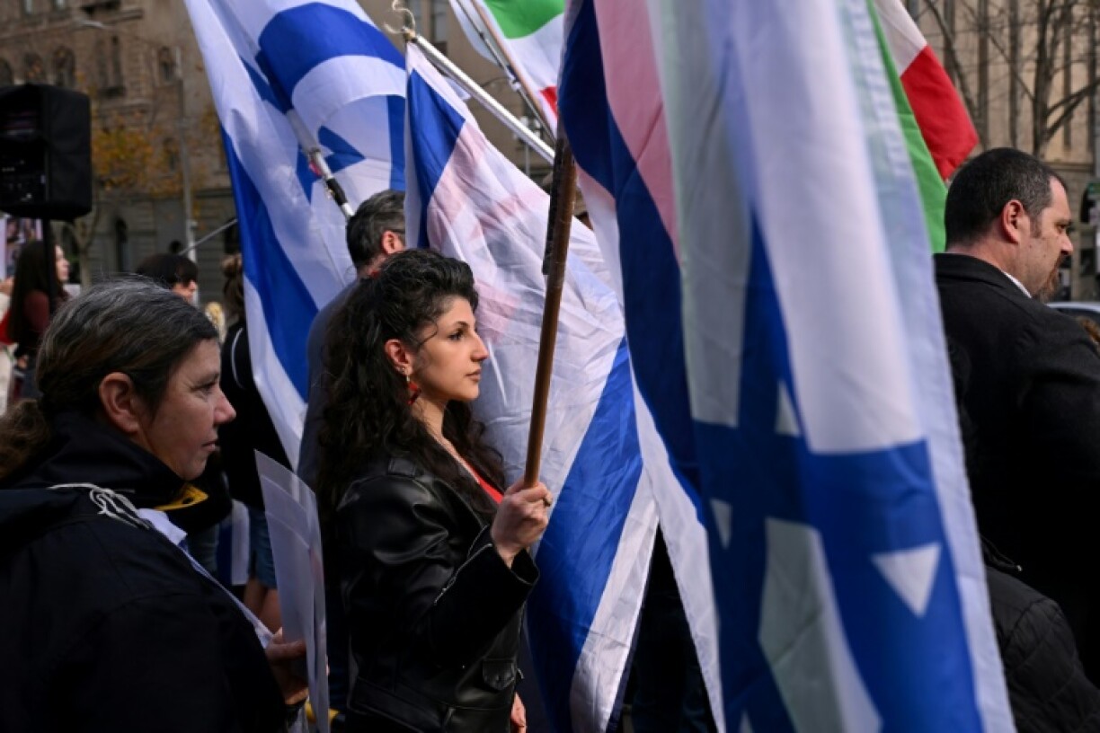 People holding the flag of Israel rally after an alleged arson attempt on a Melbourne synagogue on July 6, 2025. Jewish Australians feel