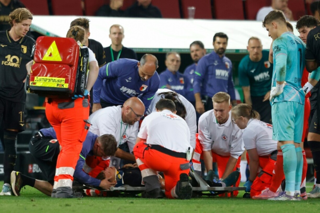 Augsburg midfielder Robin Fellhauer is treated on the pitch during the loss to Bayern Munich