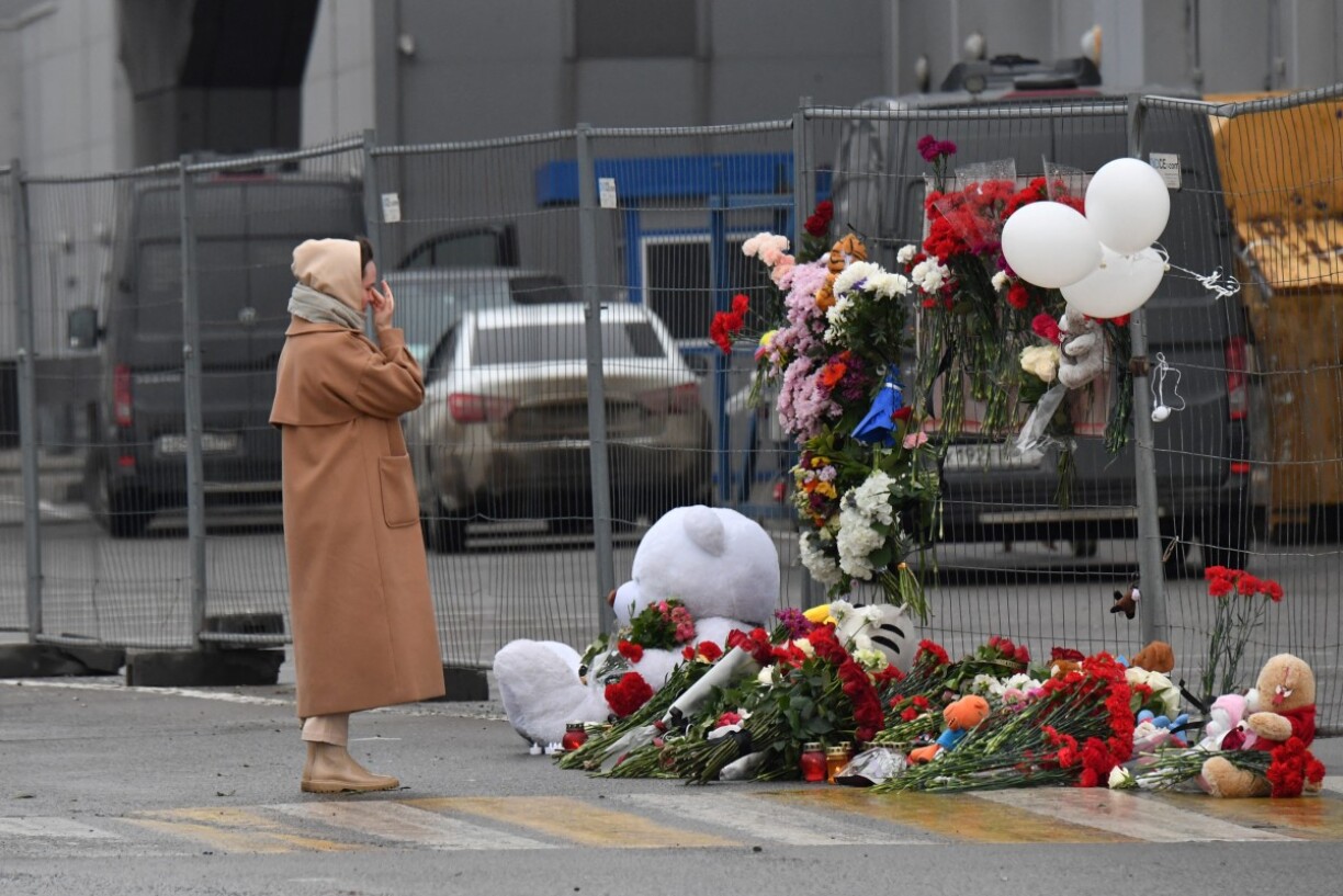 Une femme se recueille devant un mémorial dédié aux victimes de l'attaque à Moscou.