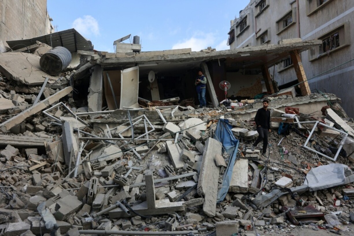 Palestinians inspect the damage after a strike hit a family home in Gaza City
