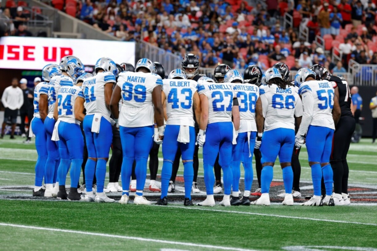 Detroit Lions and Atlanta Falcons players gather at midfield as their NFL pre-season game is suspended following an injury to Detroit's Morice Norris