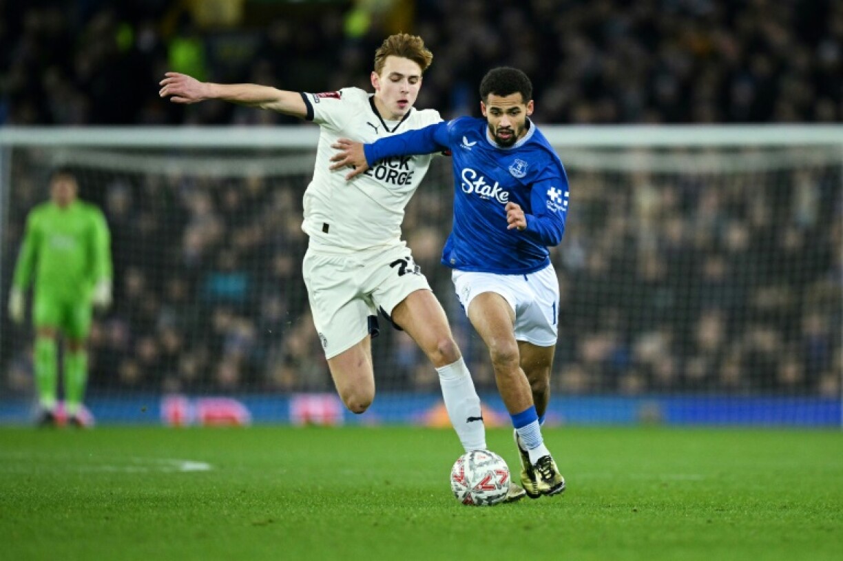 Everton forward Iliman Ndiaye (R) holds off a Peterborough United opponent during an FA Cup tie at Goodison Park.