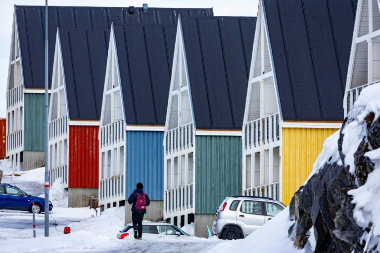 Un garçon marche sur une route résidentielle dans la ville de Nuuk, au Groenland, le 10 mars 2025