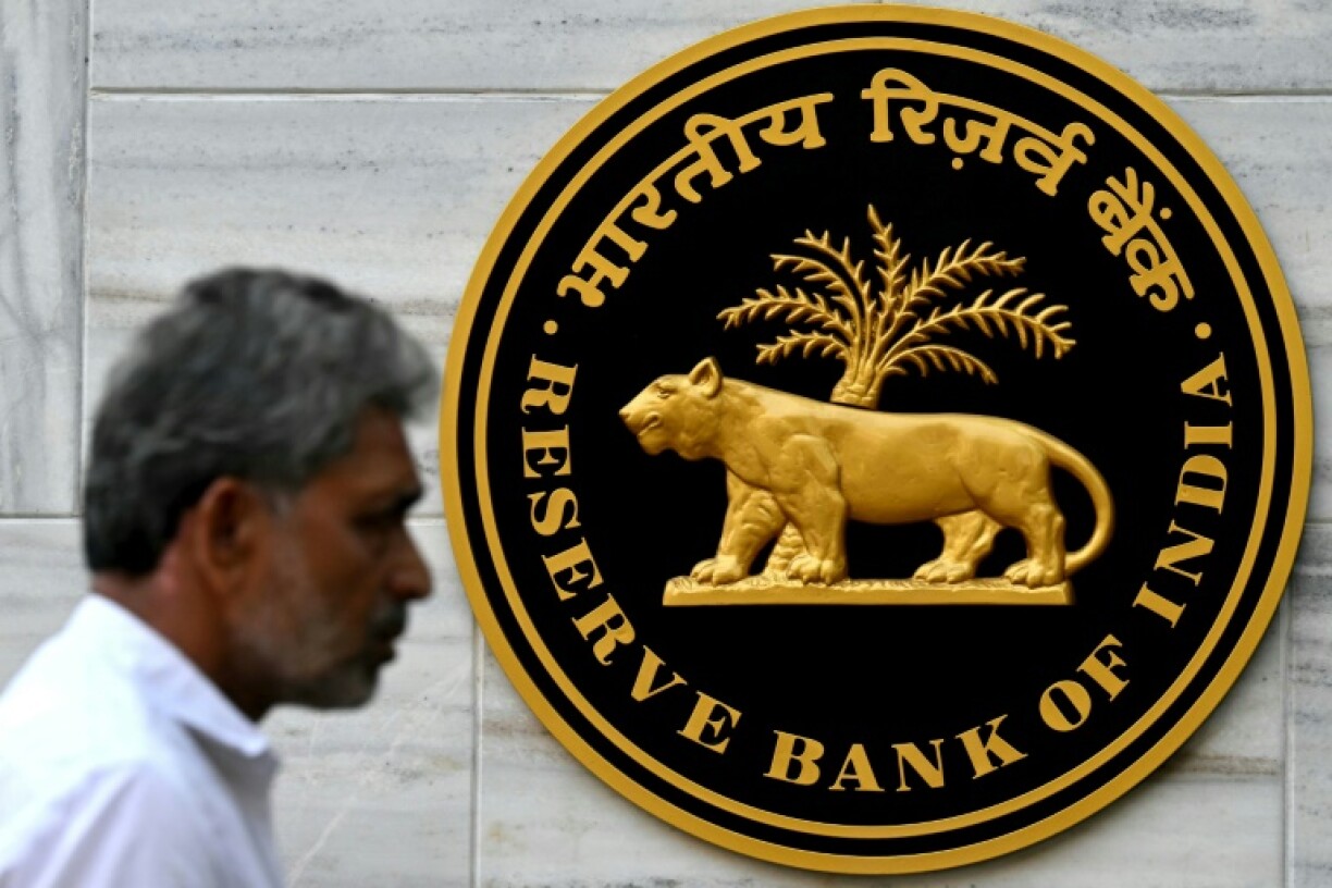 A pedestrian walks past the Reserve Bank of India (RBI) logo outside its headquarters in Mumbai