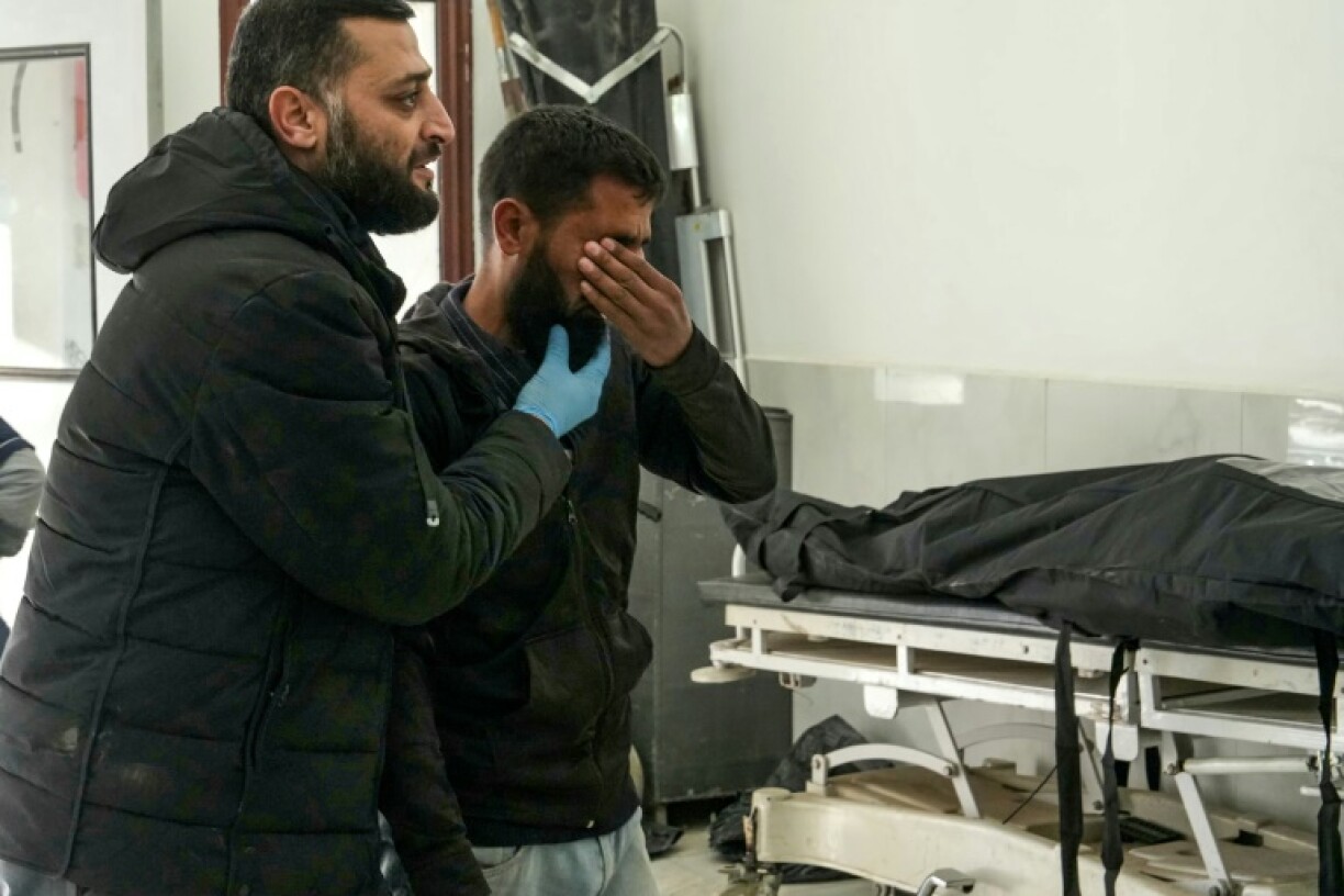 A man reacts next to a body at a hospital in Idlib, after what a war monitor said were Russian air strikes