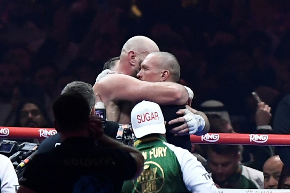 Ukraine's Oleksandr Usyk (R) and Britain's Tyson Fury (L) embrace in the ring after their heavyweight world championship rematch at the Kingdom Arena in Riyadh