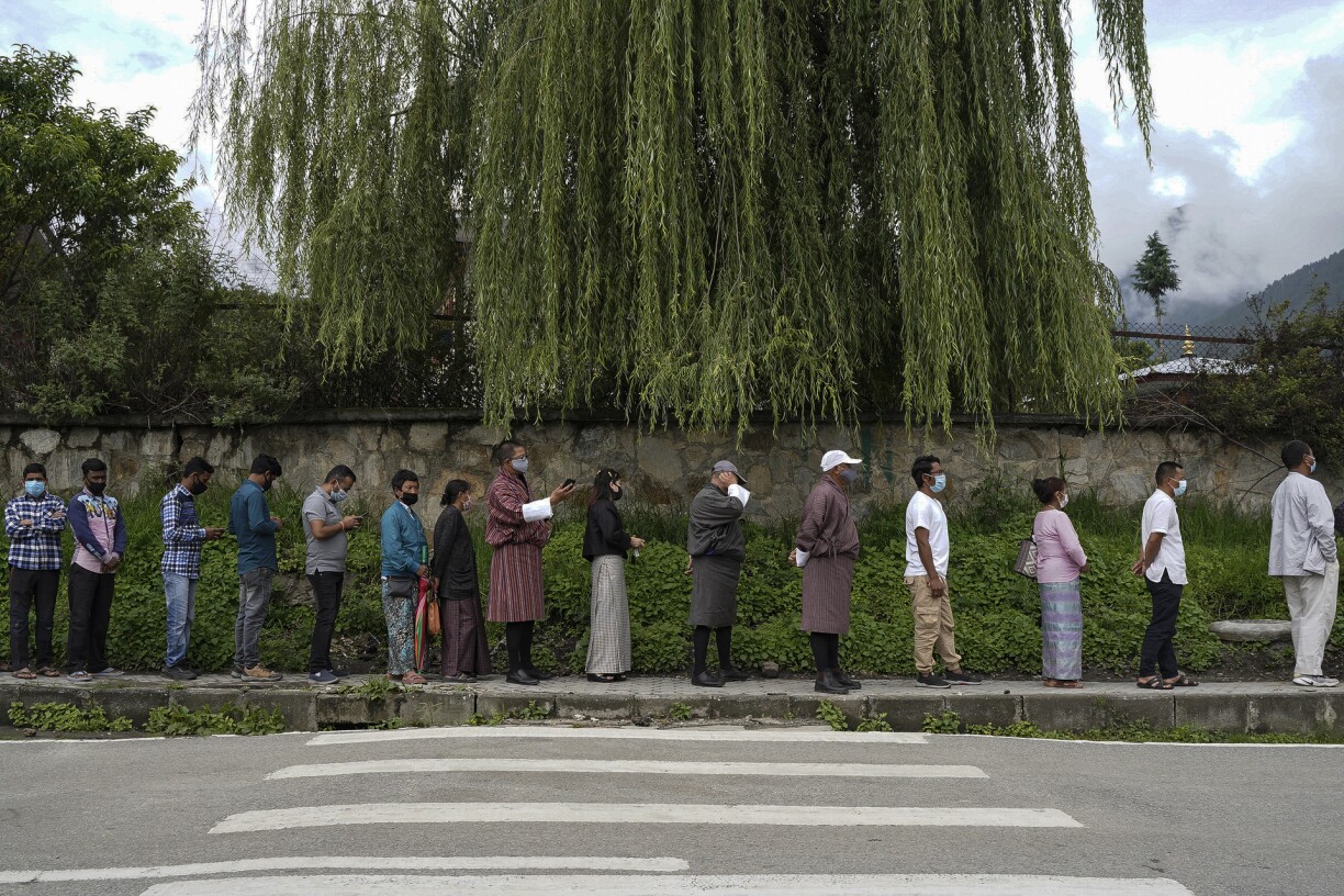 People queue up to register themselves and get inoculated with the Covid-19 coronavirus vaccine at a temporary vaccination centre in Thimpu on July 20, 2021.