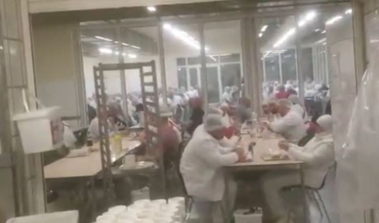 Eng Zeen, heemlech gefilmt, wéi Mataarbechter an der Corona-Kris zesummen an der Kantin sëtzen.