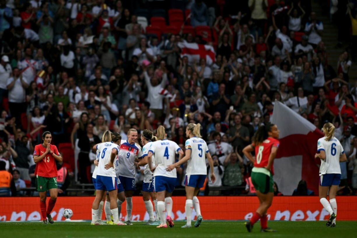 Aggie Beever-Jones (number 9) is mobbed by her England teammates after completing her Wembley hat-trick