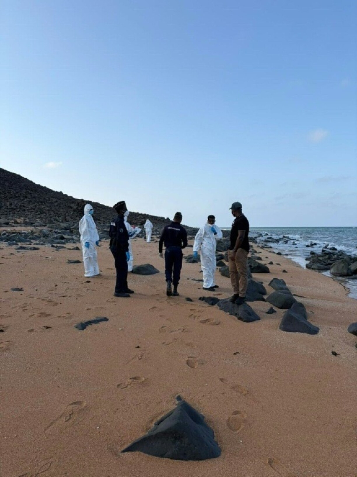 Photo diffusée par l’Organisation internationale pour les migrations (OIM) le 11 octobre 2026, montrant une équipe médico-légale et des membres des gardes-côtes djiboutiens inspectant une plage après un naufrage de bateau de migrants, à Obock (Djibouti)