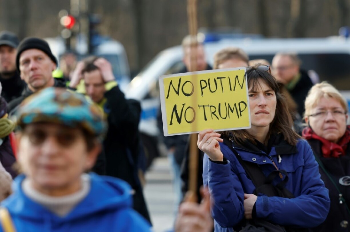 A woman holds a sign reading 'No Putin- No Trump' during a demonstration by Russian opposition members in Berlin.