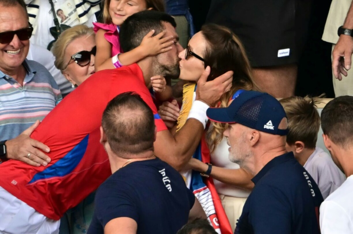 Golden Slam: Novak Djokovic gives his wife Jelena a kiss as he celebrates with his family after beating Carlos Alcaraz in the men's tennis final