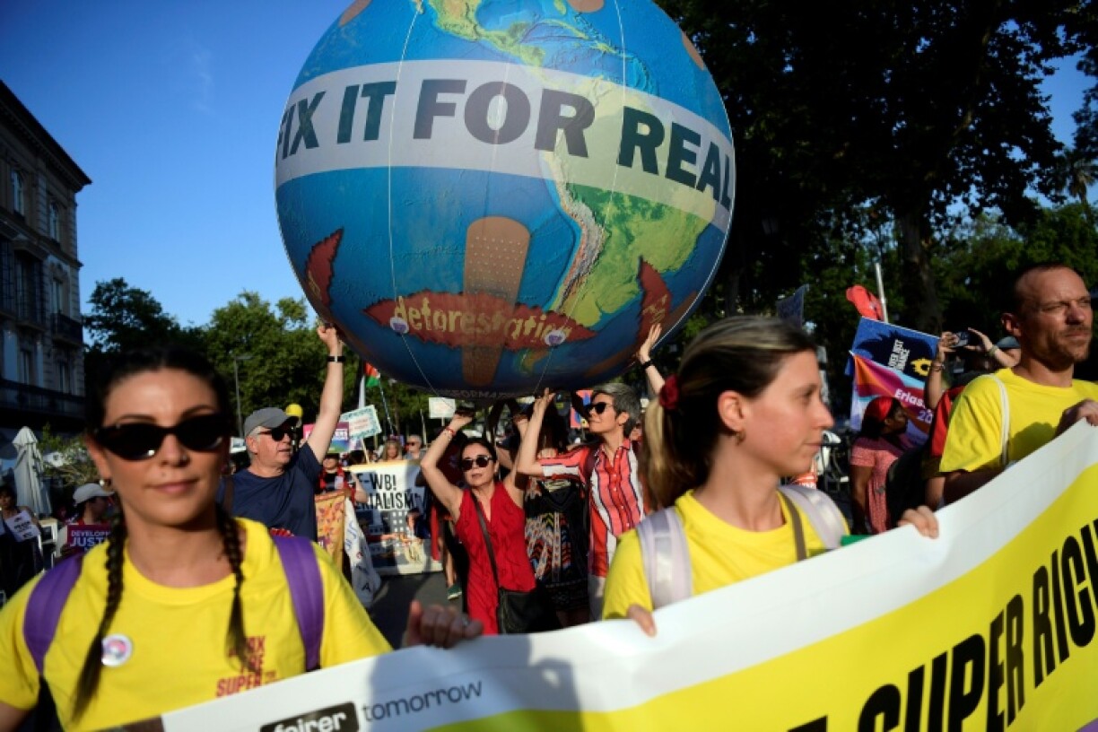 Hundreds of protesters demanded changes to global debt and tax norms in Seville on Sunday