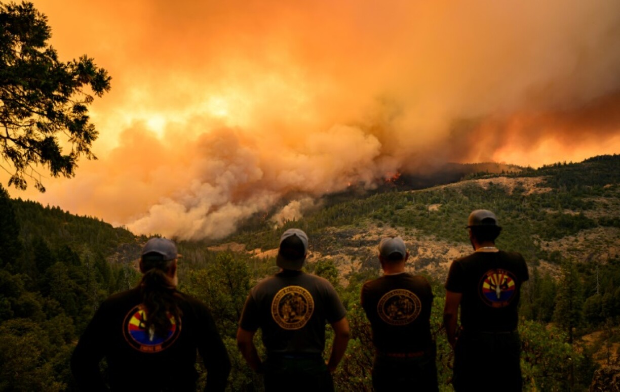 Des pompiers observent les flammes évoluant dans une vallée de la région de Forest Ranch, en Californie, le 26 juillet 2024