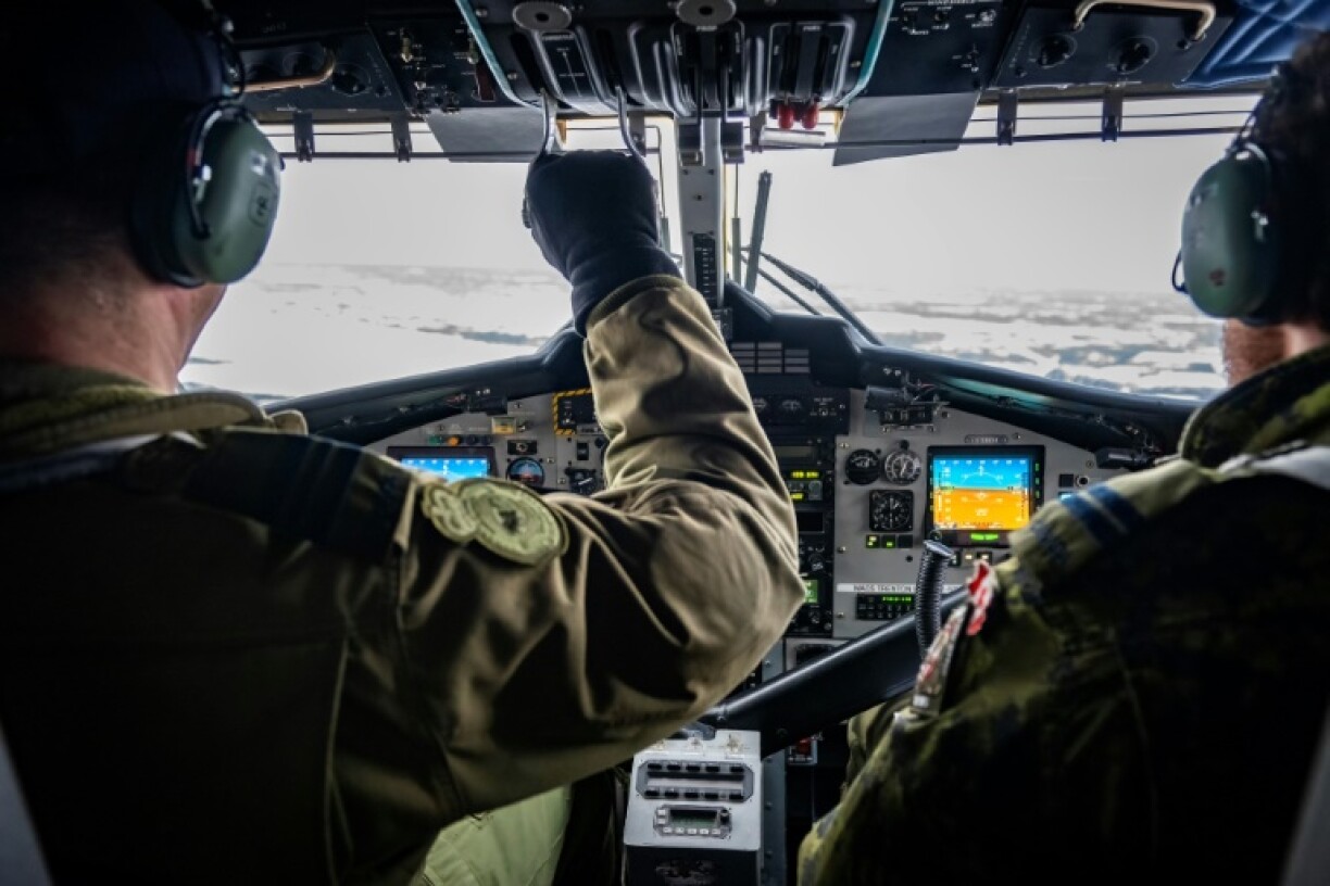 Major Marlon Mongeon (R) pilots a Twin Otter to a frozen lake in Yellowknife