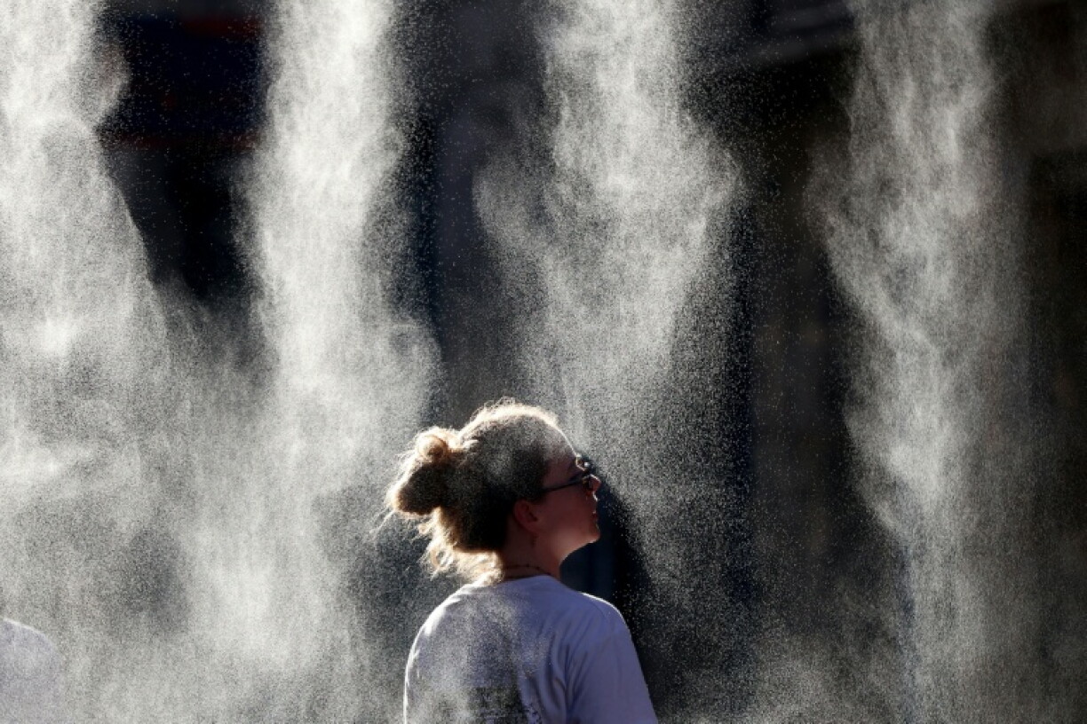 Une personne se rafraîchit avec des brumisateurs, le 21 juin 2026 à Bordeaux