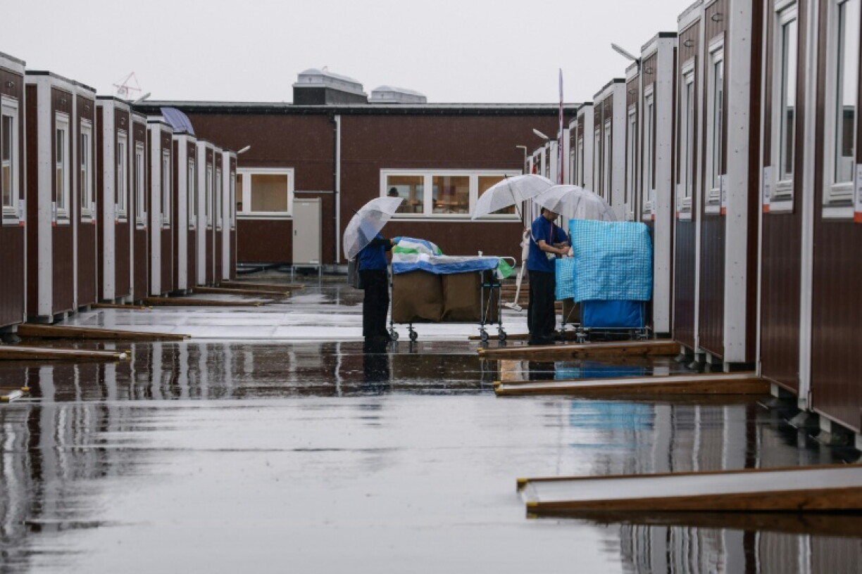 Cleaners enter a temporary container hut during a press tour in Nagoya
