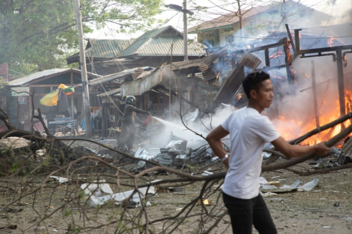 People try to extinguish fires in destroyed buildings following aerial bombardments in Singu