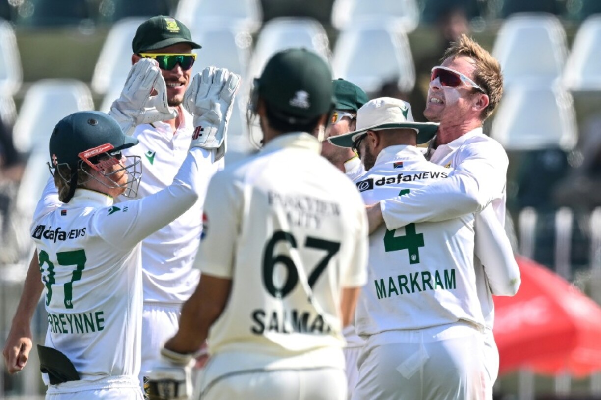 South Africa's Simon Harmer (R) celebrates with teammates after taking the wicket of Pakistan's Noman Ali