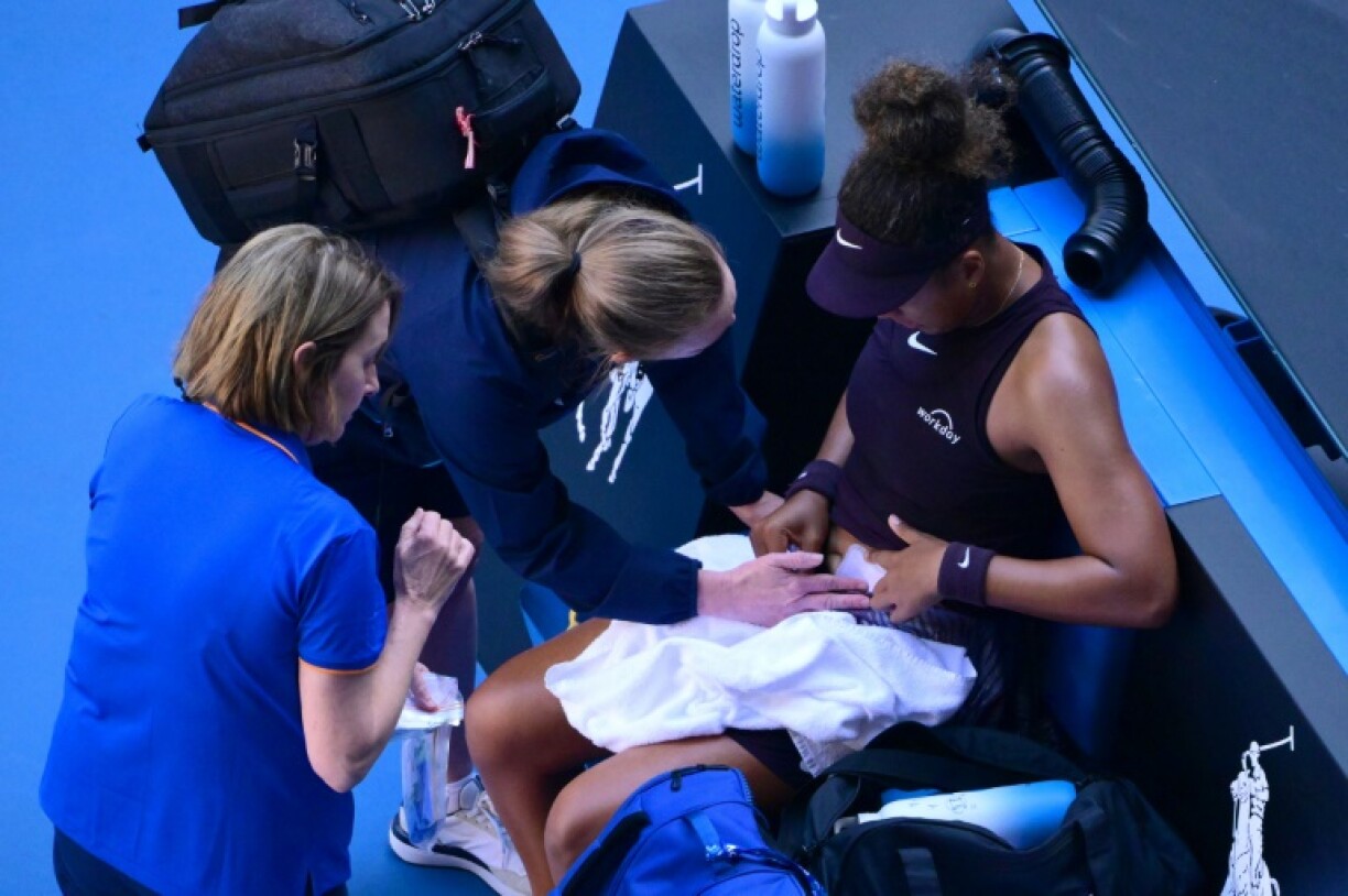 Japan's Naomi Osaka receives medical attention during her women's singles match against Switzerland's Belinda Bencic
