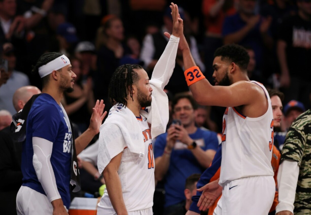 Jalen Brunson (center) high fives with teammate Karl-Anthony Towns as the New York Knicks rout the Boston Celtics to reach the NBA Eastern Conference finals