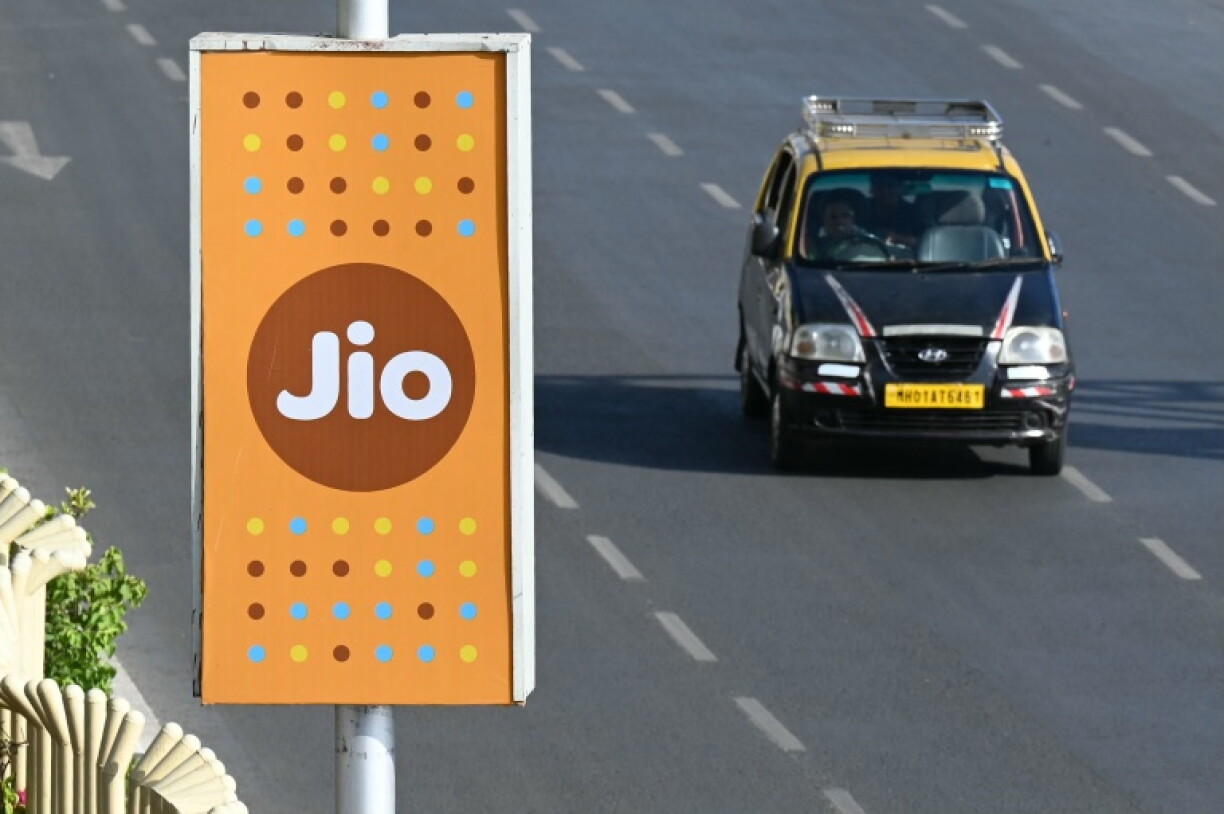 A taxi driver rides past a Jio advertisement in Mumbai on June 19, 2026