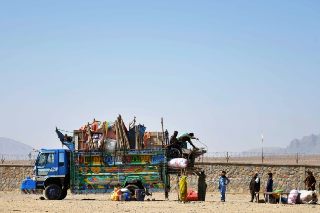 Afghan refugees unload their belongings from a truck upon their arrival from Pakistan in May