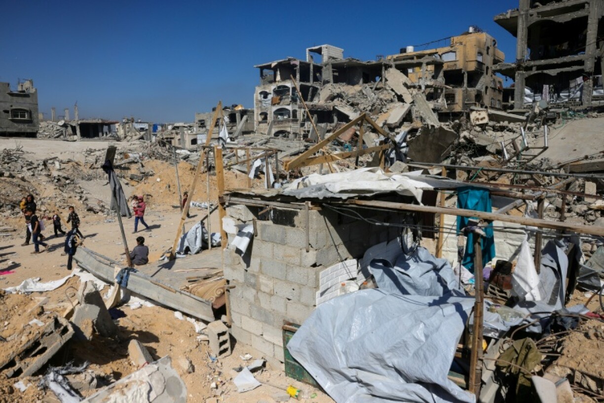 Children gather near a destroyed makeshift shelter following an Israeli strike in Beit Lahia