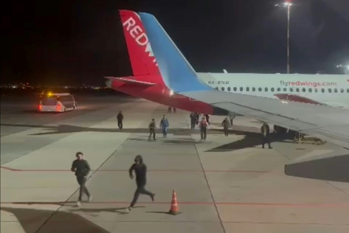 Sur cette capture d'écran d'une vidéo publiée sur la chaîne Telegram de @askrasul le 29 octobre 2023, des manifestants courent au niveau de l'aire de stationnement de l'aéroport de Makhatchkala, en Russie