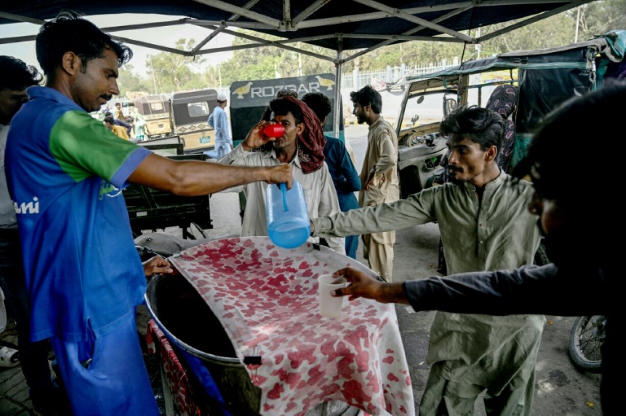 Un bénévole distribue de l'eau froide aux passants en pleine vague de chaleur à Karachi, au Pakistan, le 29 mai 2025