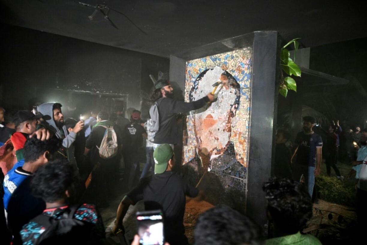 Protesters smash a mural of Bangladesh's first president, Sheikh Mujibur Rahman, the father of ousted premier Sheikh Hasina