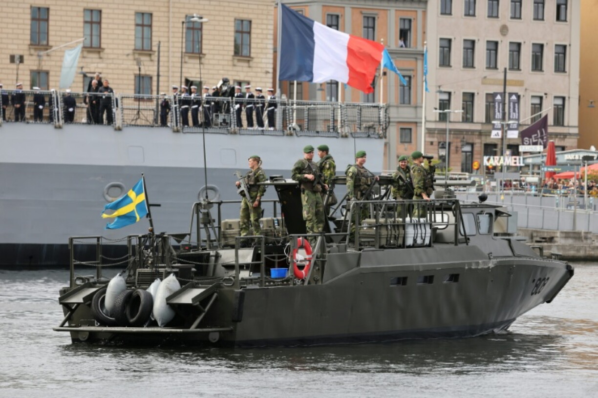 Des soldats suédois à bord d'une embarcation d'assaut rapide CB90 de la marine suédoise, devant la frégate française *Amiral Ronarc’h*, à Stockholm, le 31 août 2026 en Suède, avant la signature d'un contrat portant sur l'acquisition par la Suède de quatre frégates française de défense et d'intervention (FDI)