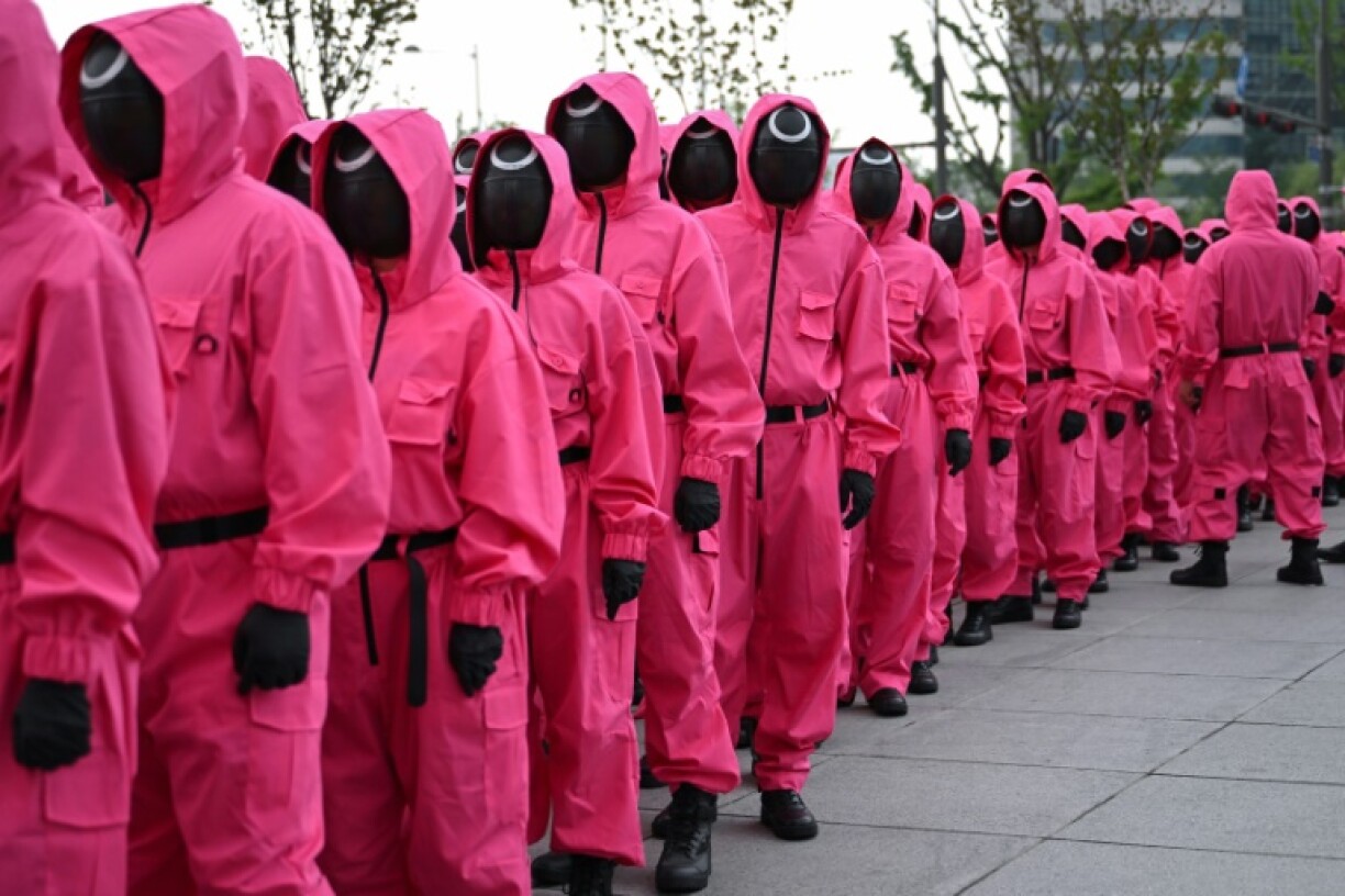 Fans gathered near Seoul's Gyeongbokgung Palace, led by marchers dressed in the bright pink uniforms worn by the show's mysterious masked agents
