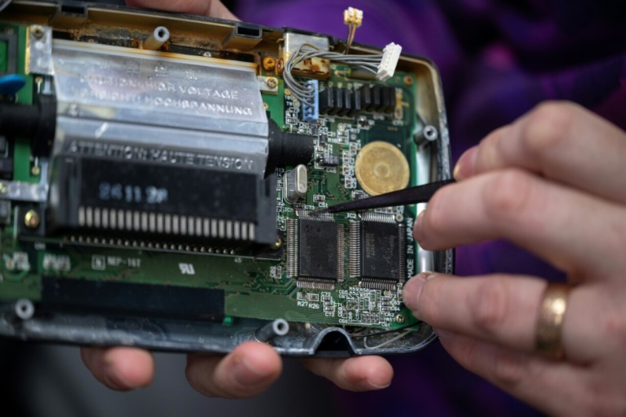 Luke Malpass repairs a hand-held Sega Game Gear video game console