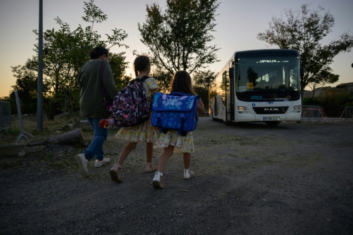 Des enfants de l'école de Pomas dans l'Aude, détruite par une tornade, rejoignent un bus pour se rendre dans une école provisoire pour la rentrée des classes le 1er septembre 2026