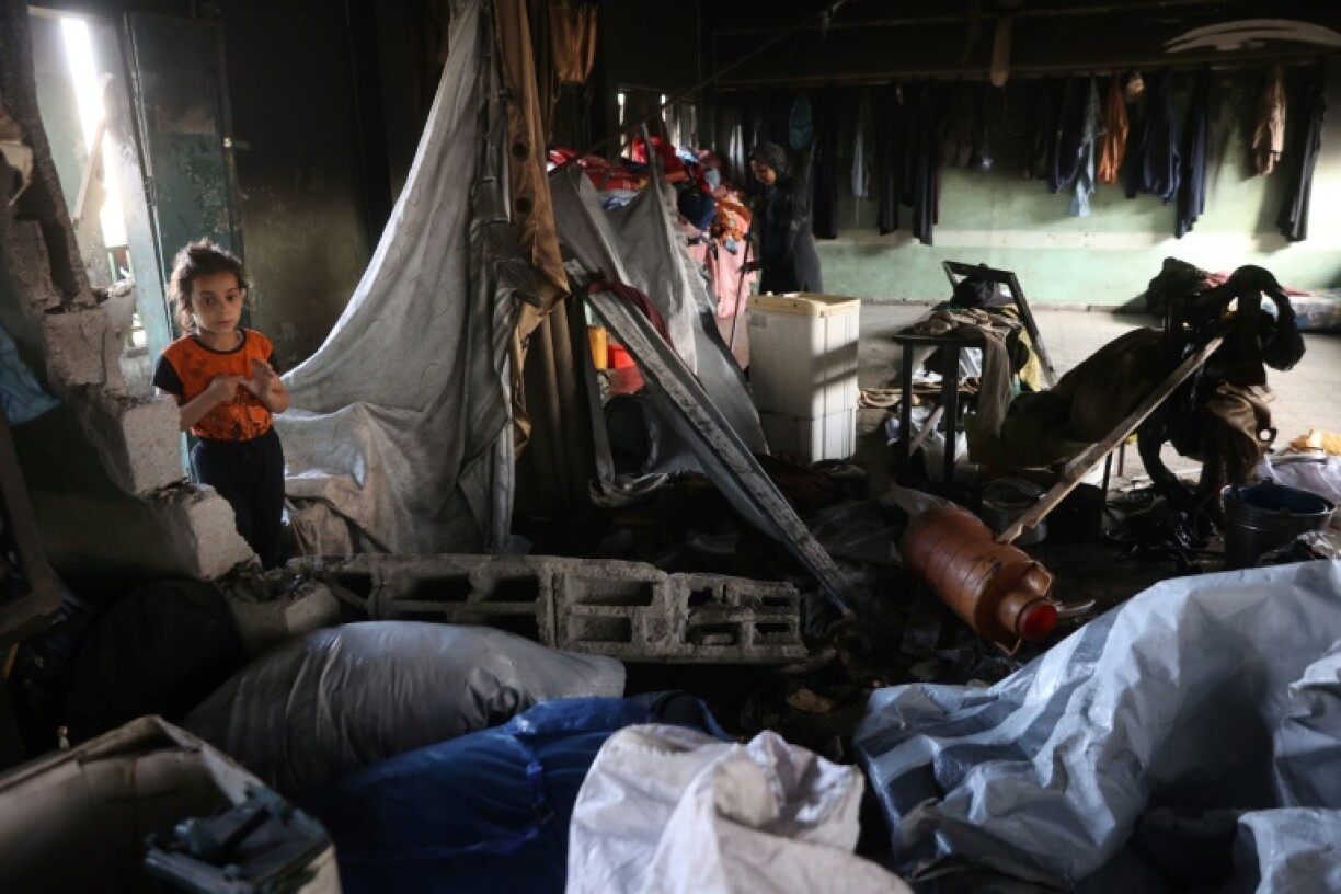 Palestinians look through the debris in a classroom after an Israeli strike hit a school serving as a shelter for displaced people