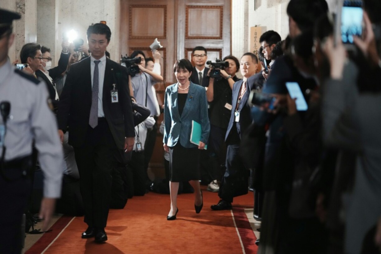 La présidente du Parti libéral démocrate (PLD) au pouvoir au Japon, Sanae Takaichi (au centre), marche avant de signer un accord à la Diète à Tokyo, le 20 octobre 2025