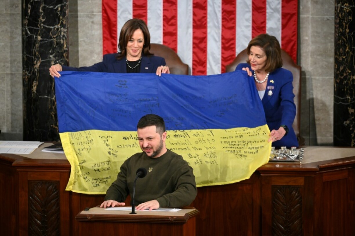 Ukraine's President Volodymyr Zelensky addresses the US Congress as US Vice President Kamala Harris and US House Speaker Nancy Pelosi hold a Ukrainian national flag he gave them on December 21, 2022